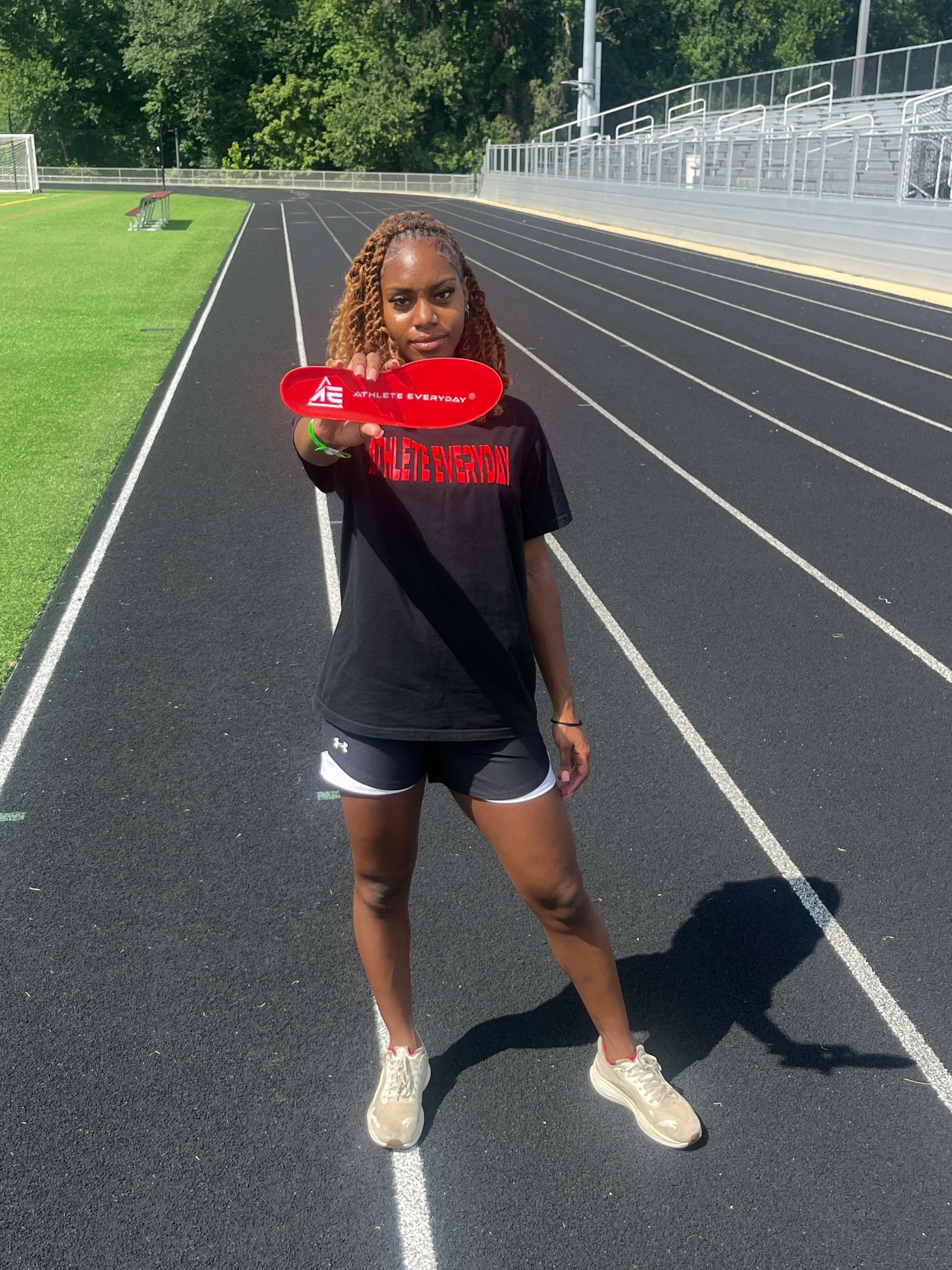 Person holding a red flag on a track and field track